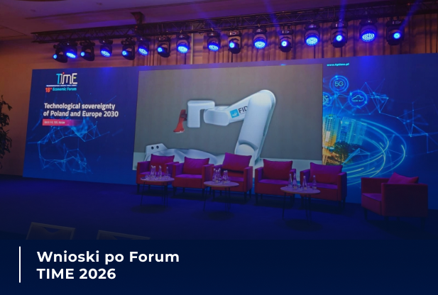 Scena przygotowana na Forum TIME 2026: na dużym ekranie prezentowana jest technologia z robotem przemysłowym, a przed ekranem ustawiono fotele i stoliki dla uczestników wydarzenia.